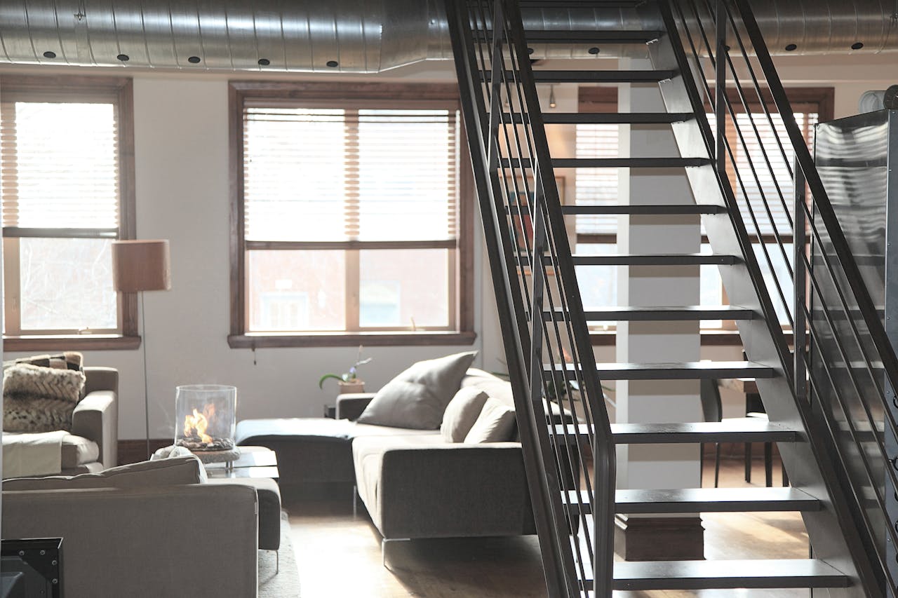 Bright and modern loft interior featuring cozy furniture and industrial elements, perfect for urban living.